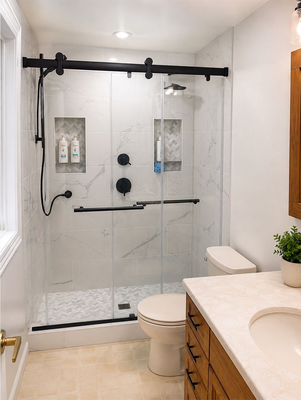 The same bathroom finished: marble-look tile, frameless glass door, black shower valve and handheld shower