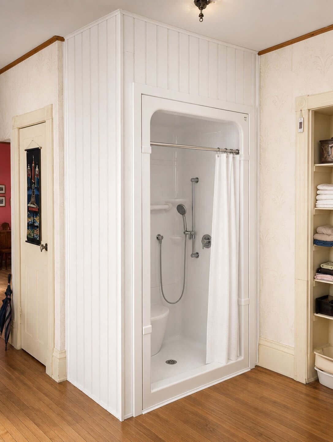 The finished barrier-free shower built into the corner of the same room, with grab bar, handheld shower and fold-down seat