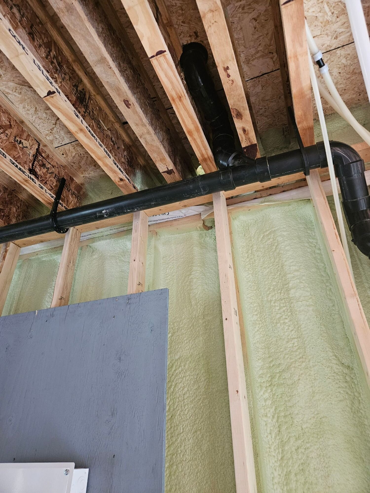 ABS drain line below the floor joists | New home plumbing, Kitchener-Waterloo ABS drain line run below the floor joists in a new home with spray-foamed walls – new home plumbing, Einwechter Plumbing & Heating, Kitchener-Waterloo