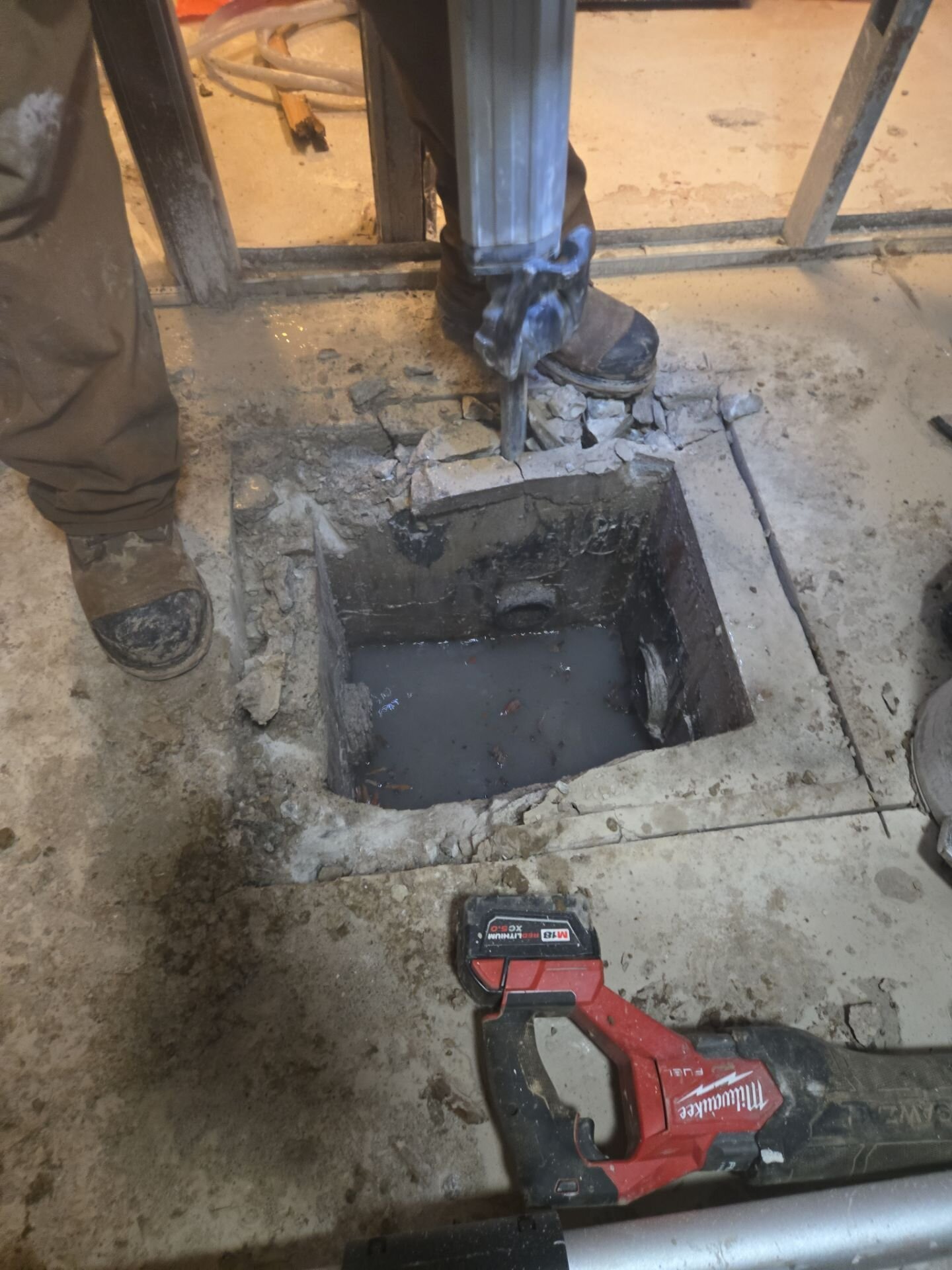 Basement concrete floor saw-cut open to reach the main drain