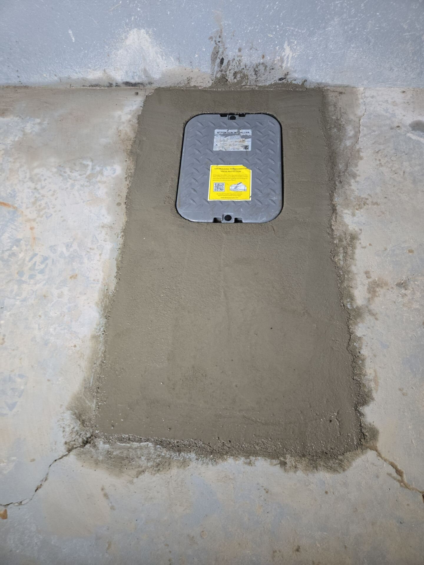 Backwater valve install, step 3 | Basement flood protection, Kitchener-Waterloo Finished backwater valve with access lid and patched concrete floor, Einwechter Plumbing & Heating, Kitchener-Waterloo