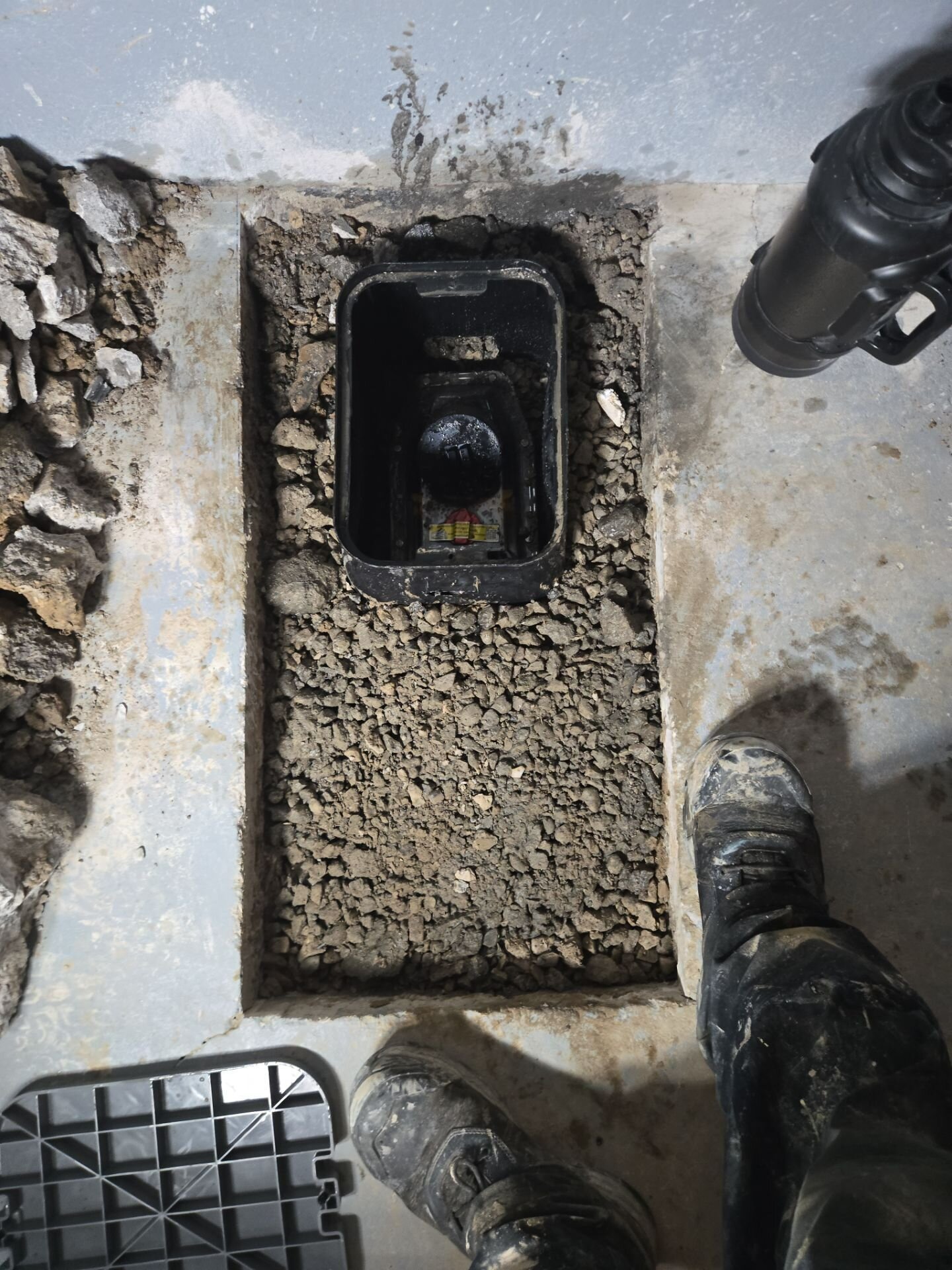 Backwater valve install, step 1 | Basement flood protection, Kitchener-Waterloo Backwater valve and access box bedded in clean stone in a basement floor, Einwechter Plumbing & Heating, Kitchener-Waterloo