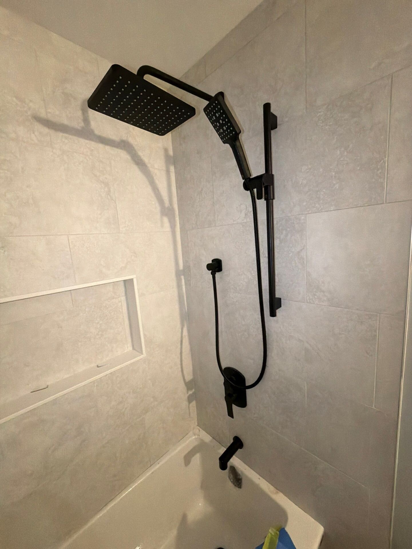 Finished matte black rain shower | New home plumbing, Kitchener-Waterloo Finished shower in a new home with a matte black rain head, hand shower on a slide bar and tub spout – new home plumbing, Einwechter Plumbing & Heating, Kitchener-Waterloo