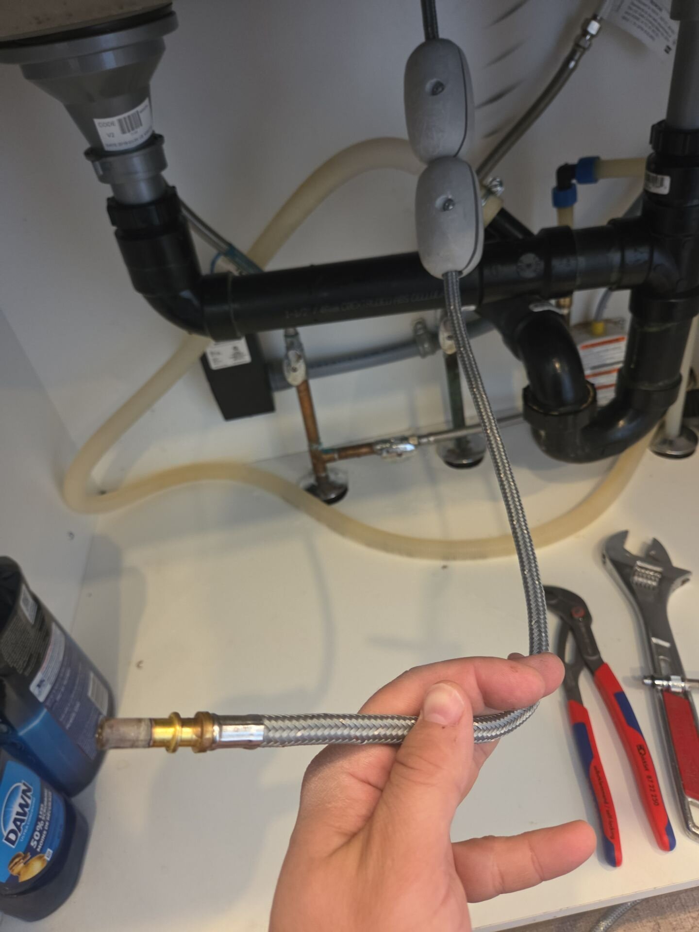 Einwechter plumber working under a kitchen sink, Kitchener-Waterloo
