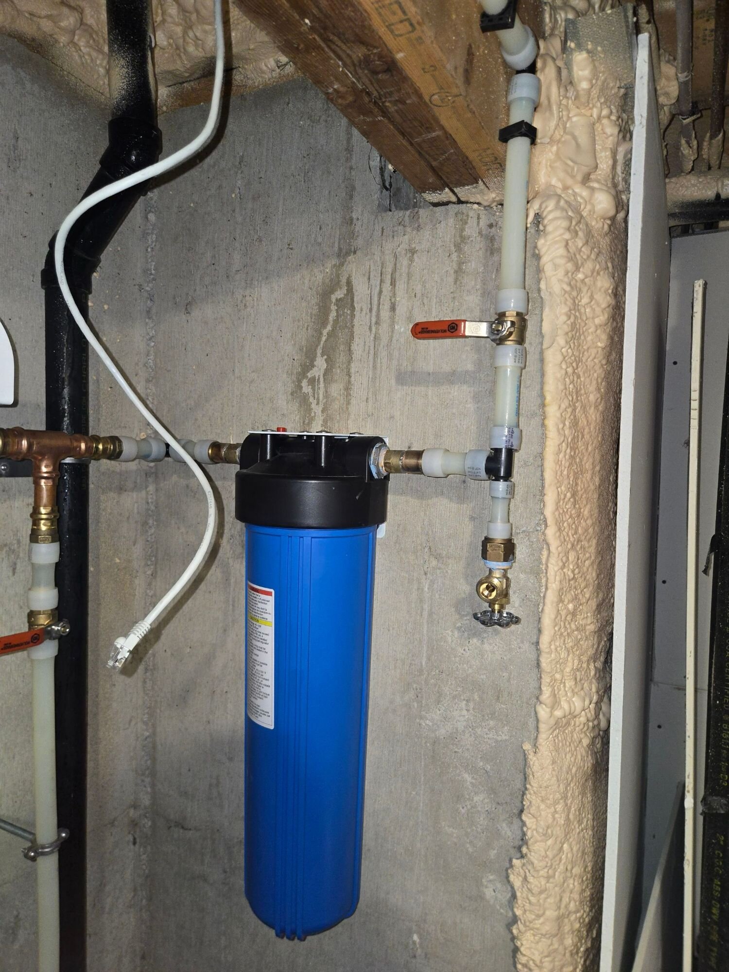 Whole-home sediment filter installed on a basement wall with bypass valves | Whole-home water filtration, Kitchener-Waterloo Whole-home sediment filter installed on a basement wall with bypass valves – whole-home water filtration, Einwechter Plumbing & Heating, Kitchener-Waterloo