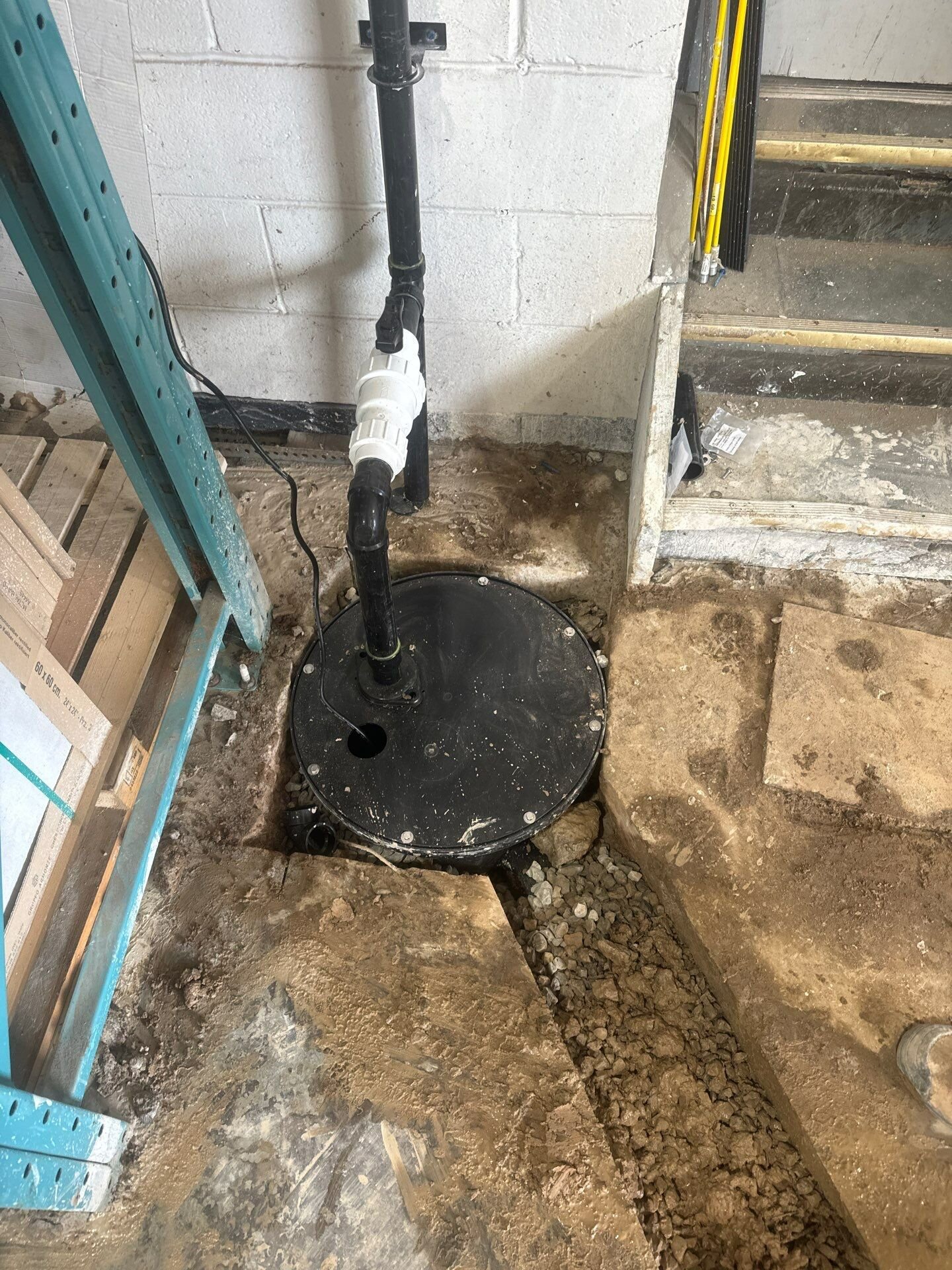 Sump pit installation for basement flood protection | Kitchener-Waterloo New sump basin with sealed lid and pump set into a basement floor by Einwechter Plumbing & Heating, Kitchener-Waterloo
