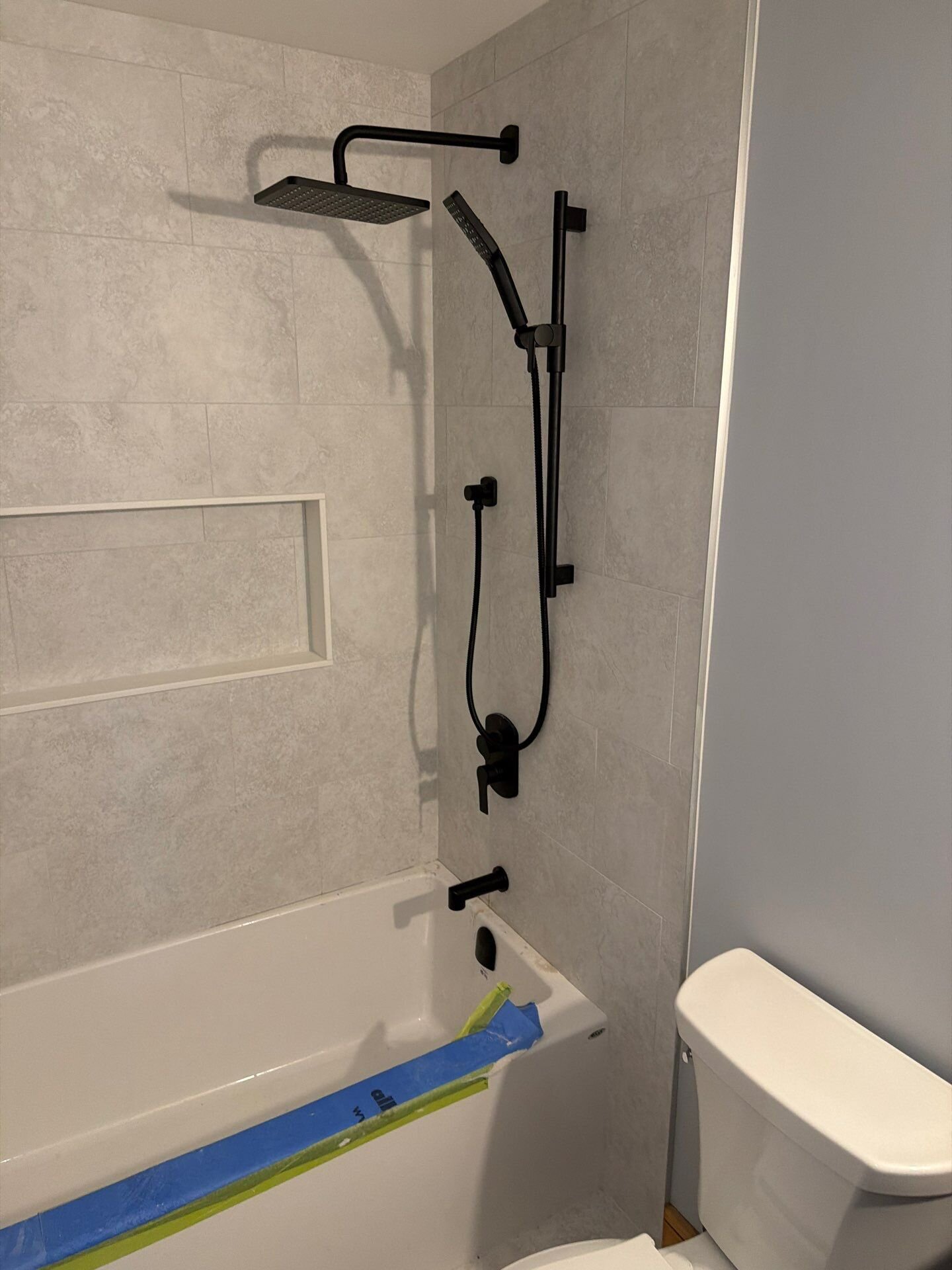 Finished tub and shower in a new home | New home plumbing, Kitchener-Waterloo Finished tub and shower with matte black fixtures and a built-in niche in a new home – new home plumbing, Einwechter Plumbing & Heating, Kitchener-Waterloo