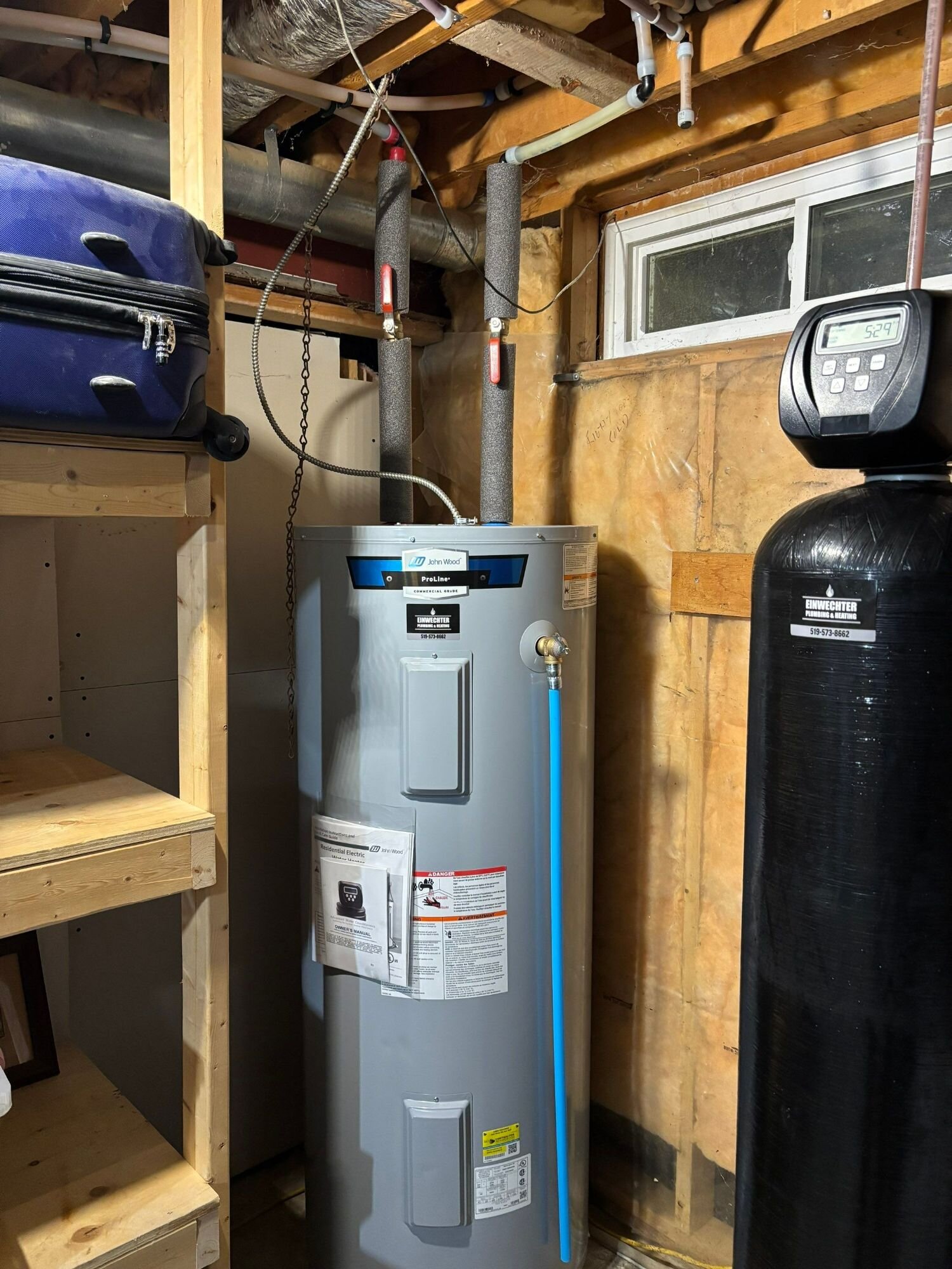 Water heater installed next to a water softener in a garage – water heater rental vs owning, Einwechter Plumbing & Heating, Kitchener-Waterloo